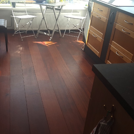 Sala de estar con suelo de madera de color rojo natural.